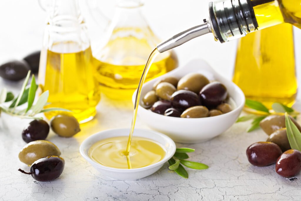 Bottle of Arbequina olive oil beside fresh salad ingredients