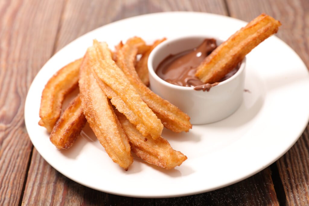 Churros served with a cup of thick hot chocolate