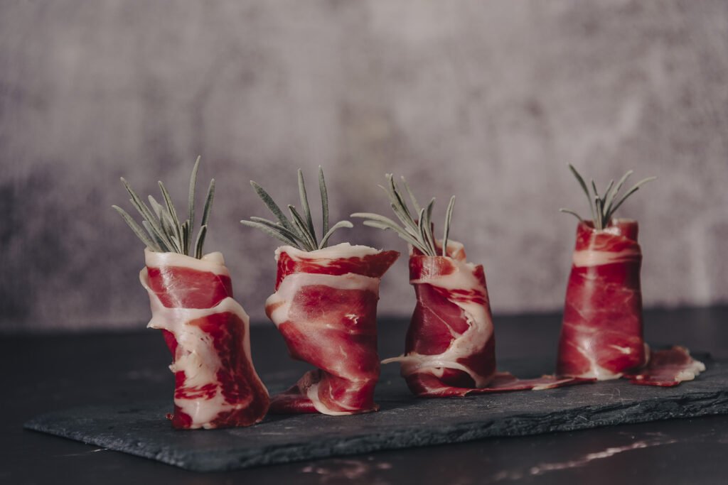Ham being carved by hand behind a tapas bar counter