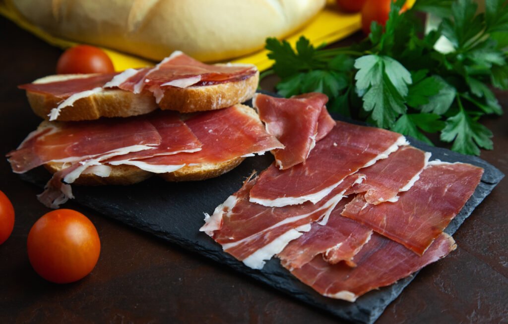 Thin slices of Serrano ham laid out on a plate